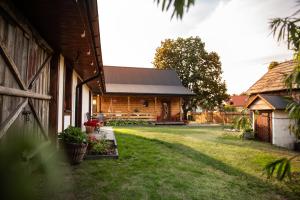 a log cabin with a yard next to a building at Siedlisko pod lipą in Józefów