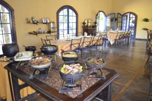 una grande stanza con un tavolo con ciotole di cibo di Fazenda Hotel Jatahy a Cavaru