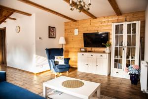 a living room with a couch and a tv at Siedlisko pod lipą in Józefów