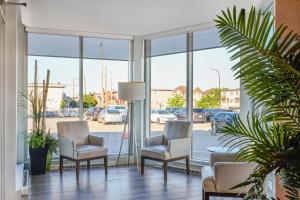 a waiting room with two chairs and windows at Hotel Newstar Montréal in Montreal
