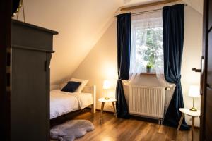 a bedroom with a bed and a window at Siedlisko pod lipą in Józefów