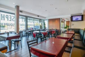 a dining room with tables and chairs and a restaurant at Hotel Newstar Montréal in Montreal