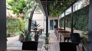 an outdoor patio with tables and chairs and plants at The Quiet Corner Guest House in Maputo