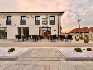 a building with tables and chairs in front of it at Family Inn in Subotica