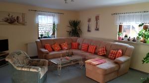sala de estar con sofá marrón y mesa en Ferienwohnung Giesa, en Jena