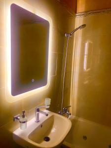 a bathroom with a sink and a mirror and a shower at Riad Nezha avec piscines jacuzzi parking à quelques minutes à pied du centre-ville in Marrakesh