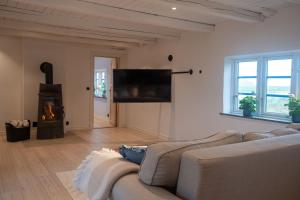 a living room with a couch and a fire place at Almeboda in Österlen in Östra Hoby