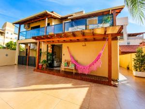 a house with a hammock on the side of it at Pousada Casa Da Praia in Florianópolis