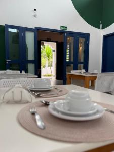 a table with plates and utensils on a table at Boulevard Pousada Boutique in Guaramiranga