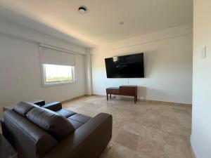 a living room with a couch and a flat screen tv at San Germán in Guasave