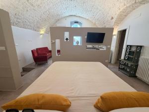 a bedroom with a large bed and a tv at Casa Maresca in Ostuni