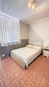 ein Schlafzimmer mit einem Bett in einem Zimmer mit Fenster in der Unterkunft Casa Fè in Fregene