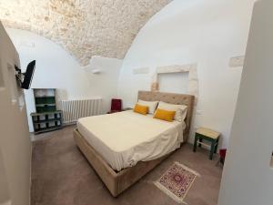 a bedroom with a bed with yellow pillows at Casa Maresca in Ostuni