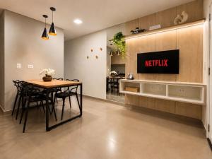 a kitchen and dining room with a table and a tv at Yolanda Flats in Foz do Iguaçu