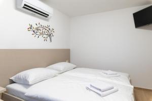 a bedroom with a bed with white pillows and a tv at Terra rossa rooms in Čepljani +3 photos
