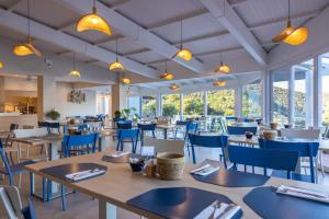 a dining room with tables and chairs and windows at Hotel Paradiso in Portoferraio