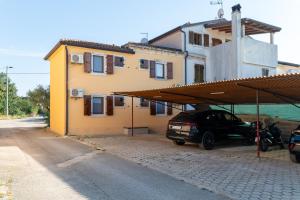 a car parked in front of a house at Terra rossa rooms in Čepljani