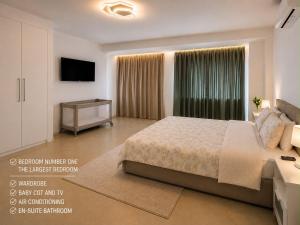 a bedroom with a large bed and a television at Del Mar Modern Spacious 3-Bedroom Apartment Near the Beach in Puerto de Sagunto