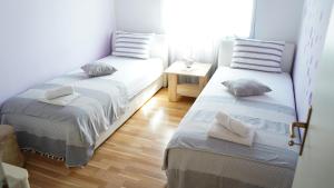 two twin beds in a room with a table at Apartmani Vela Luka in Vela Luka