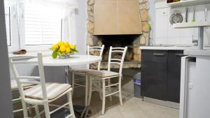 a kitchen with a table and chairs and a fireplace at Apartmani Vela Luka in Vela Luka