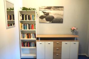 a room with a book shelf with books at Moderne offene Wohnung in Bad Sulza +3 photos