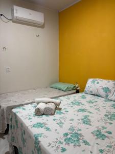 ein Schlafzimmer mit zwei Betten und einem Ventilator an der Wand in der Unterkunft Chalés do mar in Icapuí