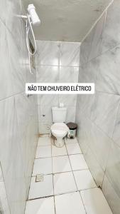 a bathroom with a toilet in a white tiled room at Por do Sol Praia Hotel in Fortaleza +42 photos