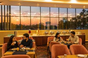 a group of people sitting at tables in a restaurant at Sudama Palace - Free Temple Pass For Guests in Ayodhya +29 photos