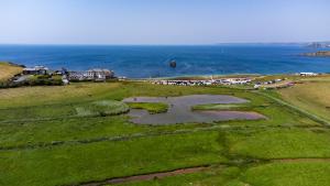 an aerial view of a field with a body of water at Devon Belltents - South Milton in Hope Cove