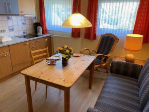 a kitchen with a wooden table with flowers on it at Nordsee 405 in Wangerooge