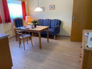 a living room with a table and a blue couch at Nordsee 405 in Wangerooge +2 photos