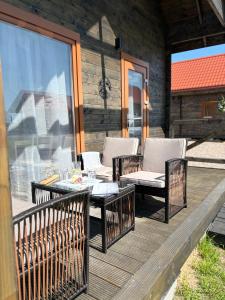 a patio with chairs and a table on a deck at KOPA LIVING seaside holiday homes in Nida