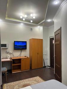 a room with a desk and a television on a wall at Dostyq in Astana +10 photos