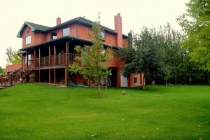 una gran casa roja con un gran patio en South Africa House Guest Lodge en Wainwright