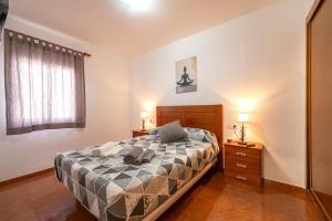 a bedroom with a bed and two night stands with lamps at Apartamento By Llu in Alcalá la Real