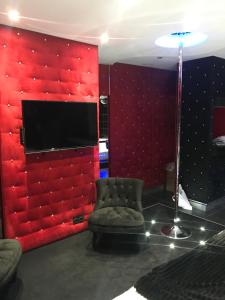 A television and/or entertainment centre at Le Cabaret Vip SPA