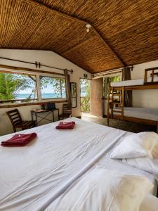 a large bed with two red towels on top of it at El Marabu Chill'n Surf in Aposentillo