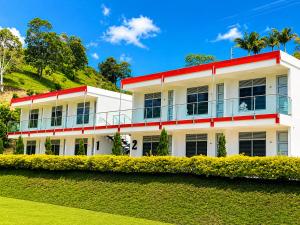 a white building with a red trim at Hotel Takuara in Vergara