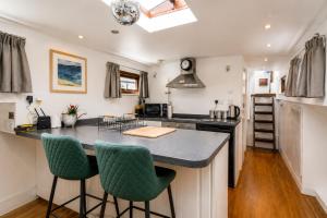 a kitchen with a large island with green bar stools at Historic Dutch Barge, Idyllic location in London