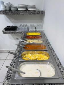 a row of trays of food in a refrigerator at Alameda Hotel Centro in Garanhuns