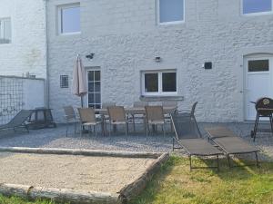 a patio with a table and chairs and an umbrella at El Rozère in Cerfontaine