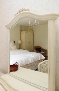 a bedroom with a white bed and a mirror at Ty Llwyd in Treffynnon 