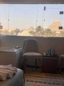 a room with a chair and a window with a view at Irit pyramids inn in Cairo