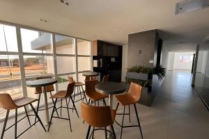 a kitchen with tables and chairs in a room with windows at Studio Nova Betânia - Barreto - in Mossoró