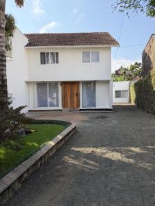 a white house with a driveway in front of it at City Retreat Arusha in Arusha