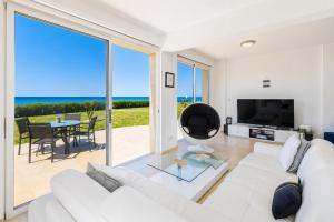 a living room with a white couch and a large window at Villa Myla in Kato Yialia