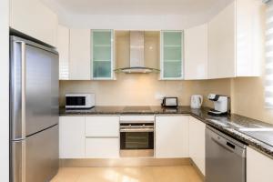 a kitchen with white cabinets and a stainless steel refrigerator at Villa Myla in Kato Yialia