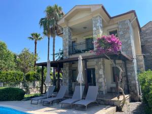 a house with chairs and a swimming pool at Villa Caretta Luna in Ortaca
