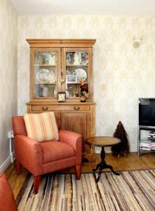 a living room with a chair and a table at Ty Llwyd in Treffynnon  +7 photos