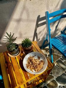 a table with a bowl and plants on it next to a chair at Mindy s Home in Lien Nghiia
